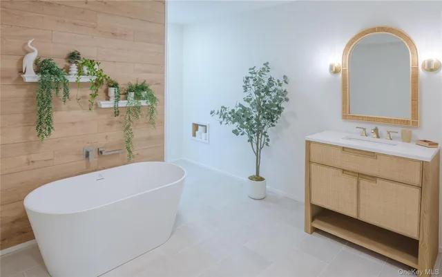 a bathroom with a bathtub a sink and a mirror