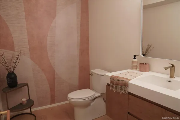 a bathroom with a sink a toilet and a mirror