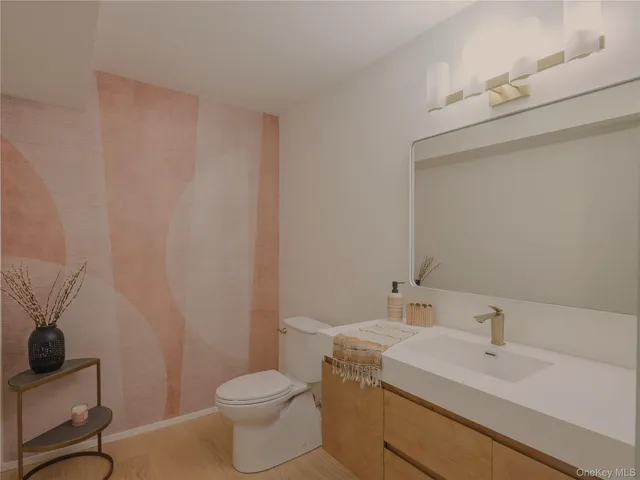 a bathroom with a sink a toilet and mirror