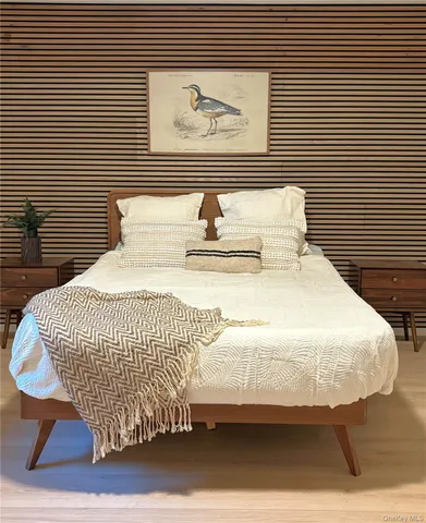 a bedroom with a bed and painting on the wall