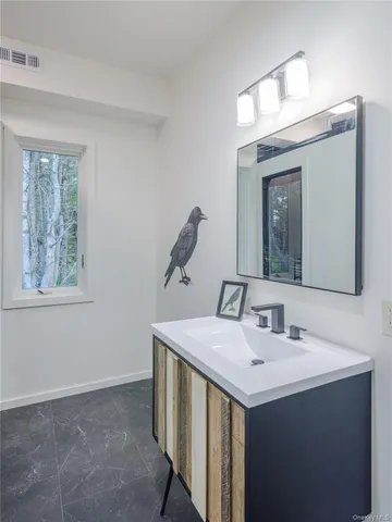 a bathroom with a sink vanity and a mirror