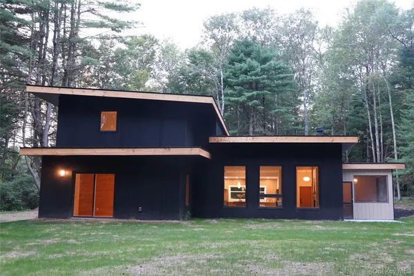 a front view of house with yard and glass top table and chairs