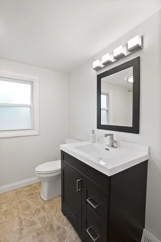 a bathroom with a toilet sink and mirror