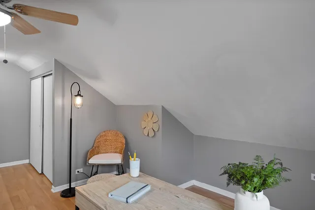 a view of a bedroom with a bed and wooden floor
