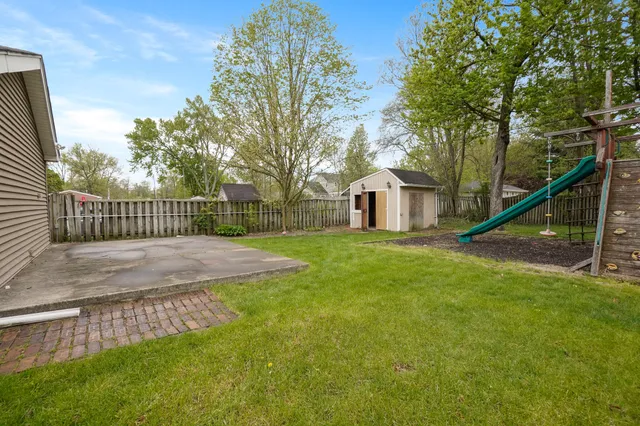 a view of a house with a fence and a tree