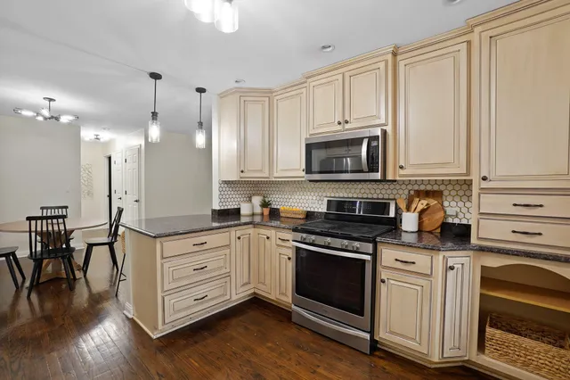 a kitchen with granite countertop a stove a sink and a microwave