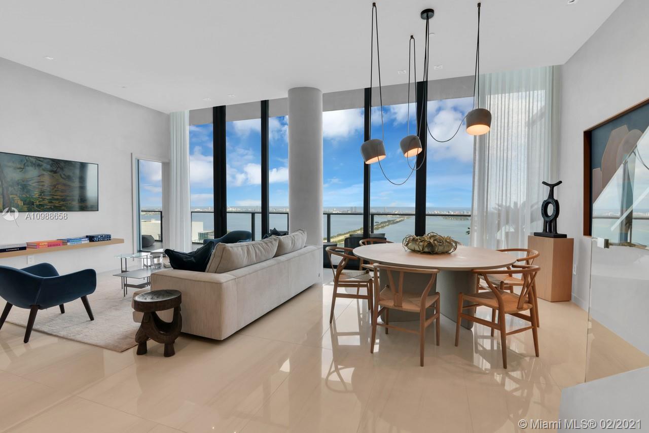 480 Northeast 31st Street, Unit PH5402 Miami, FL 33137 - Photo 2 of 35 a living room with couches a coffee table and a flat screen tv