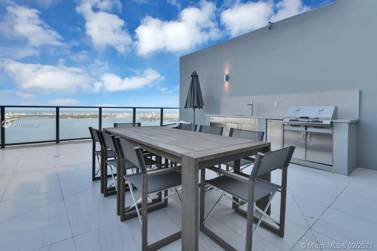 480 Northeast 31st Street, Unit PH5402 Miami, FL 33137 - Photo 28 of 35 a view of a dinning table and chairs in patio