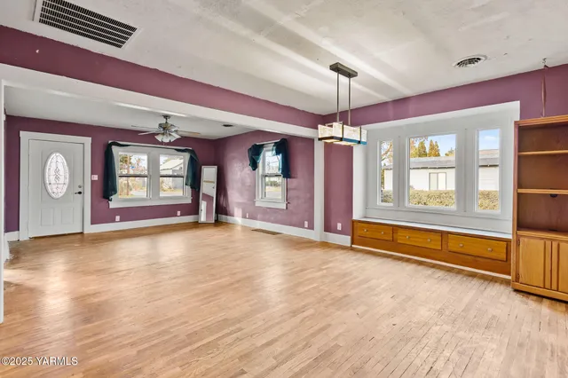 a view of an empty room with window and cabinet