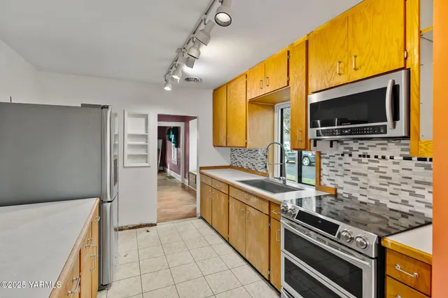 a kitchen with stainless steel appliances kitchen island granite countertop a sink and cabinets