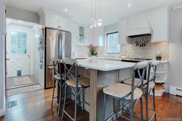 a kitchen with stainless steel appliances a refrigerator a stove a dining table and chairs