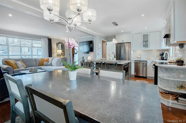 a kitchen with stainless steel appliances granite countertop a stove a sink a microwave a refrigerator and cabinets