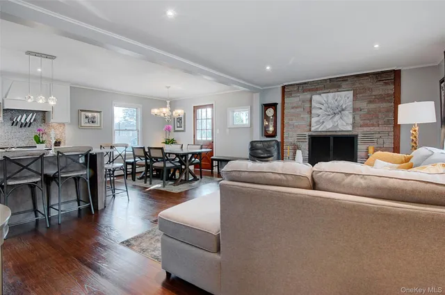 a living room with furniture a flat screen tv and kitchen view