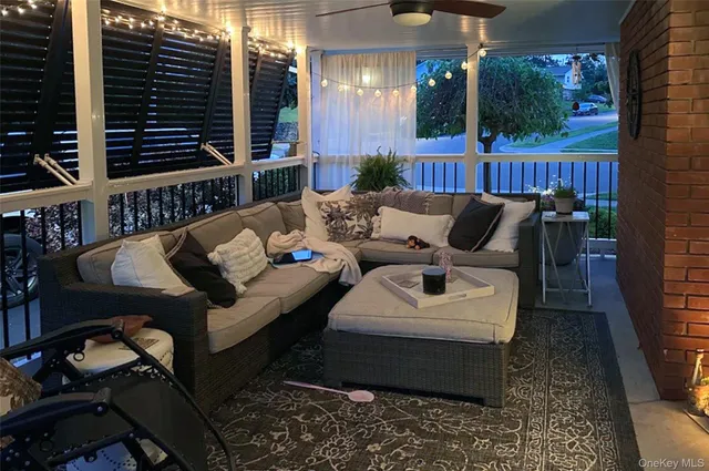 a view of a patio with couches table and chairs with wooden floor and fence