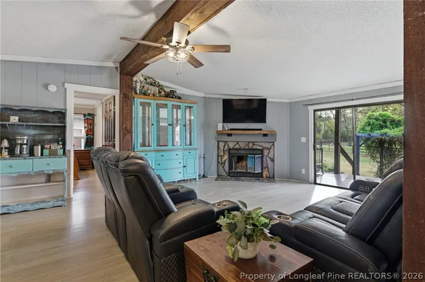 a kitchen with stainless steel appliances granite countertop a refrigerator a stove a sink and white cabinets with wooden floor