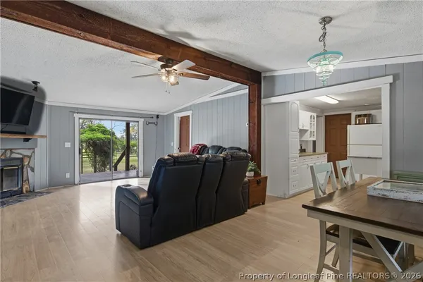 a living room with furniture a flat screen tv and a large window