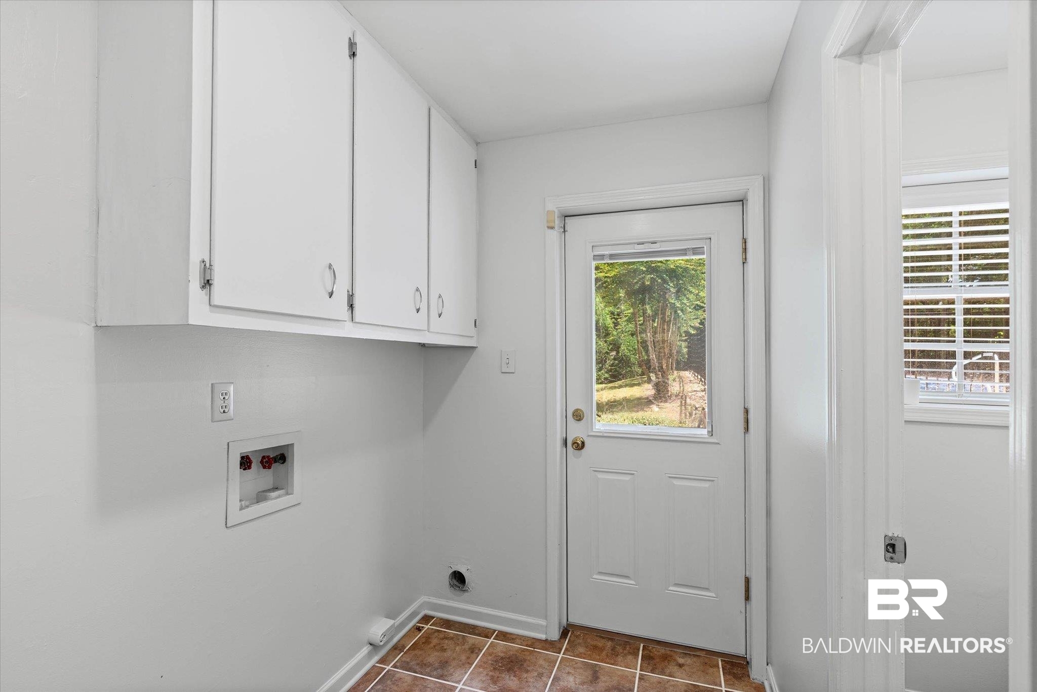 8301 Fordham Road Mobile, AL 36619 - Photo 25 of 57 Utility room featuring white cabinetry, a rear exterior door with a glass insert, a window with horizontal blinds, and a tiled floor