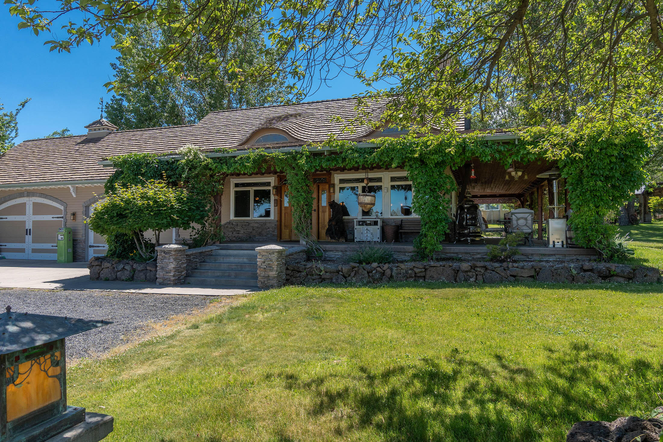 21925 Bear Creek Road Bend, OR 97702 - Photo 60 of 104 Front entryway with handmade copper and glass lights in the style of Green & Green, 4-car garage w/2 roll up garage doors made to look like barn doors