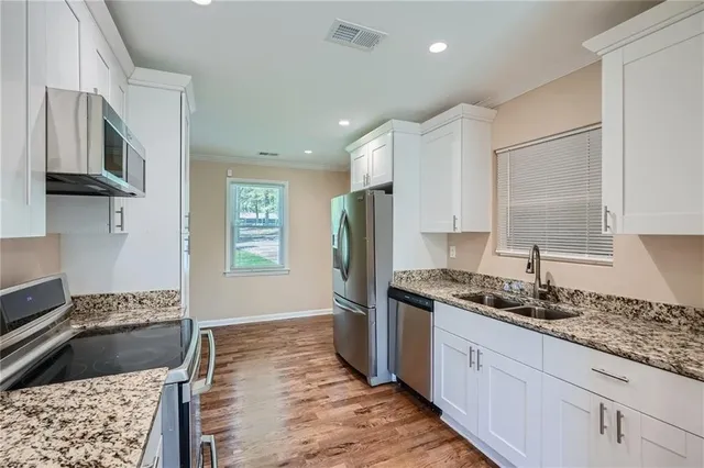 a kitchen with stainless steel appliances granite countertop a sink stove and refrigerator