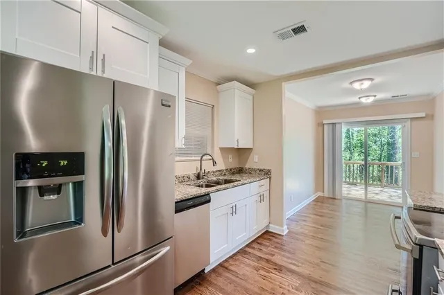 a kitchen with stainless steel appliances a refrigerator sink and cabinets