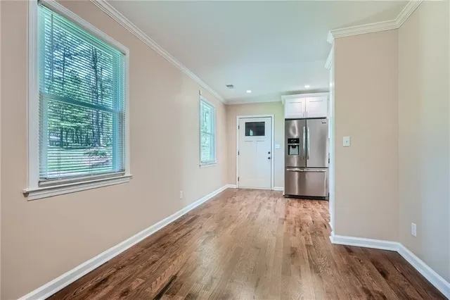 a view of empty room with wooden floor and window