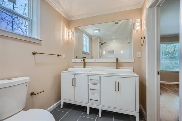 a spacious bathroom with a double vanity sink and a toilet