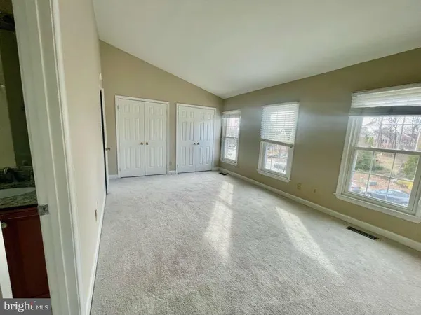 a view of an empty room with a fireplace and a window