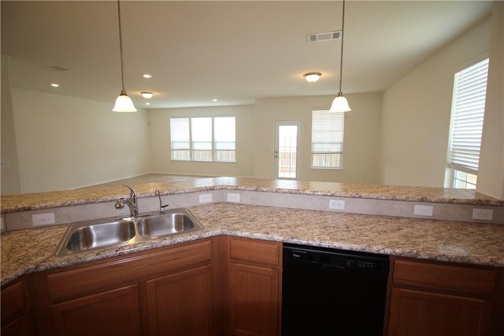7200 Altidore Drive Austin, TX 78744 - Photo 23 of 23 a kitchen with granite countertop a sink a counter space and a window