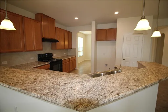 a kitchen with granite countertop a sink a counter space and a window