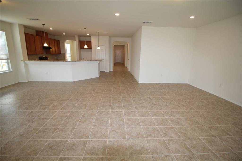 7200 Altidore Drive Austin, TX 78744 - Photo 6 of 23 a view of an empty room and a kitchen