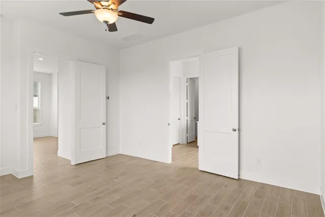 an empty room with fan and entrance