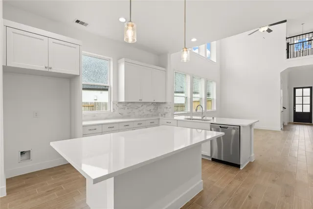 a large kitchen with kitchen island white cabinets and wooden floor