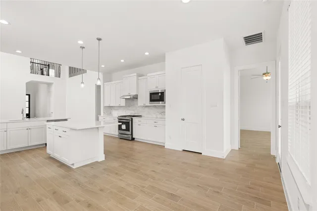 a large white kitchen with stainless steel appliances