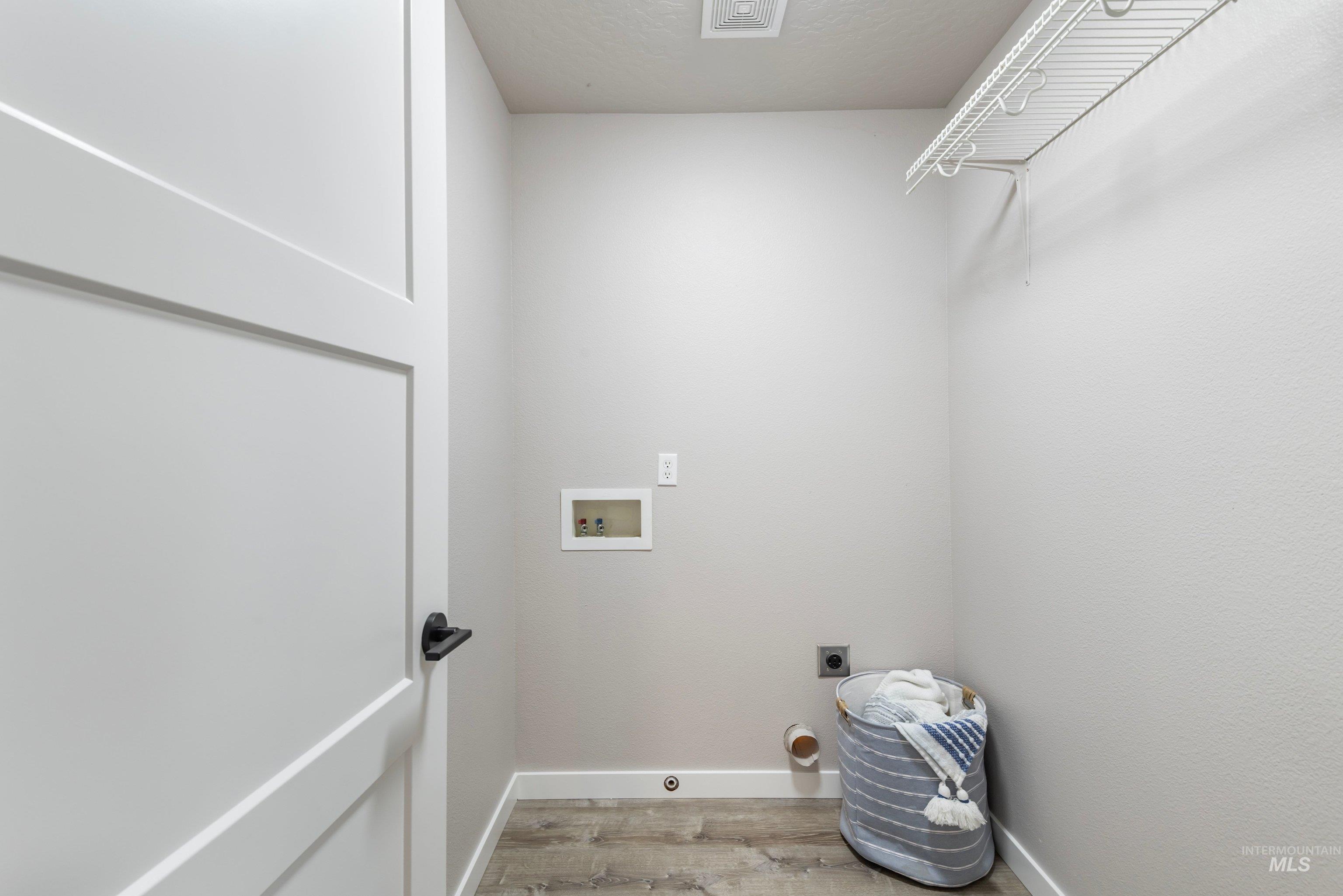 16759 Abram Avenue Caldwell, ID 83607 - Photo 26 of 33 Dedicated laundry area featuring wood-finish flooring, light neutral wall paint, and a white wire shelving unit