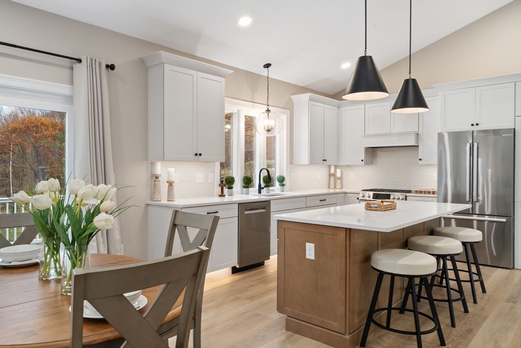 29-4 Sunset Road Westminster, MA 01473 - Photo 11 of 37 a kitchen with stainless steel appliances a sink a stove a refrigerator a dining table and chairs