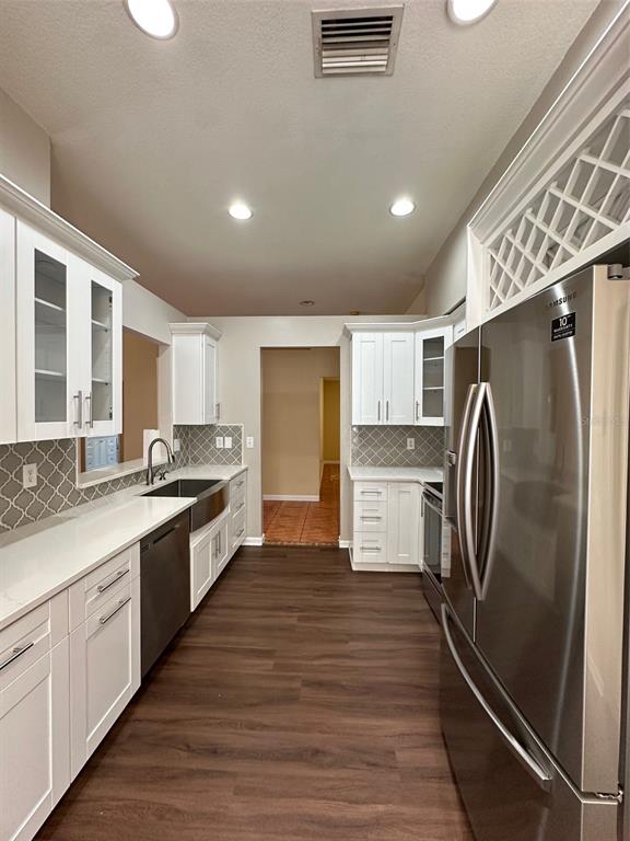 5541 Dark Star Loop Wesley Chapel, FL 33544 - Photo 8 of 14 a large kitchen with a center island wooden floor and stainless steel appliances