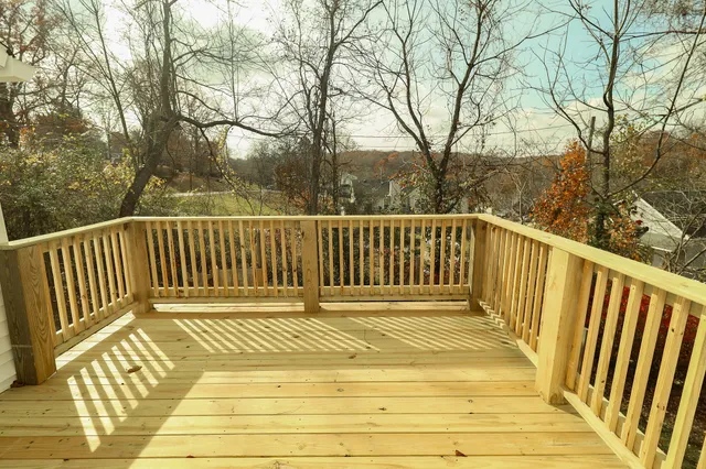 a view of balcony with wooden floor and fence
