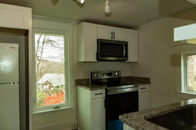 a kitchen with a stove a sink and a window