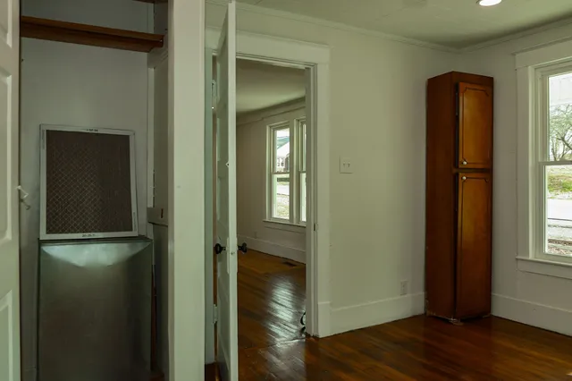 a view of a hallway with wooden floor and closet area