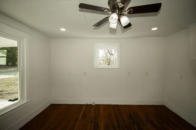 en empty room with wooden floor and windows