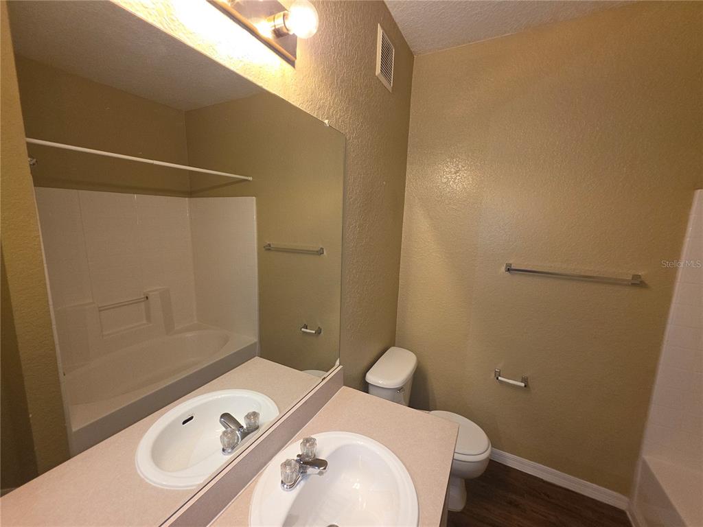 824 Grand Regency Pointe, Unit 101 Altamonte Springs, FL 32714 - Photo 13 of 14 a bathroom with a sink and mirror with toilet