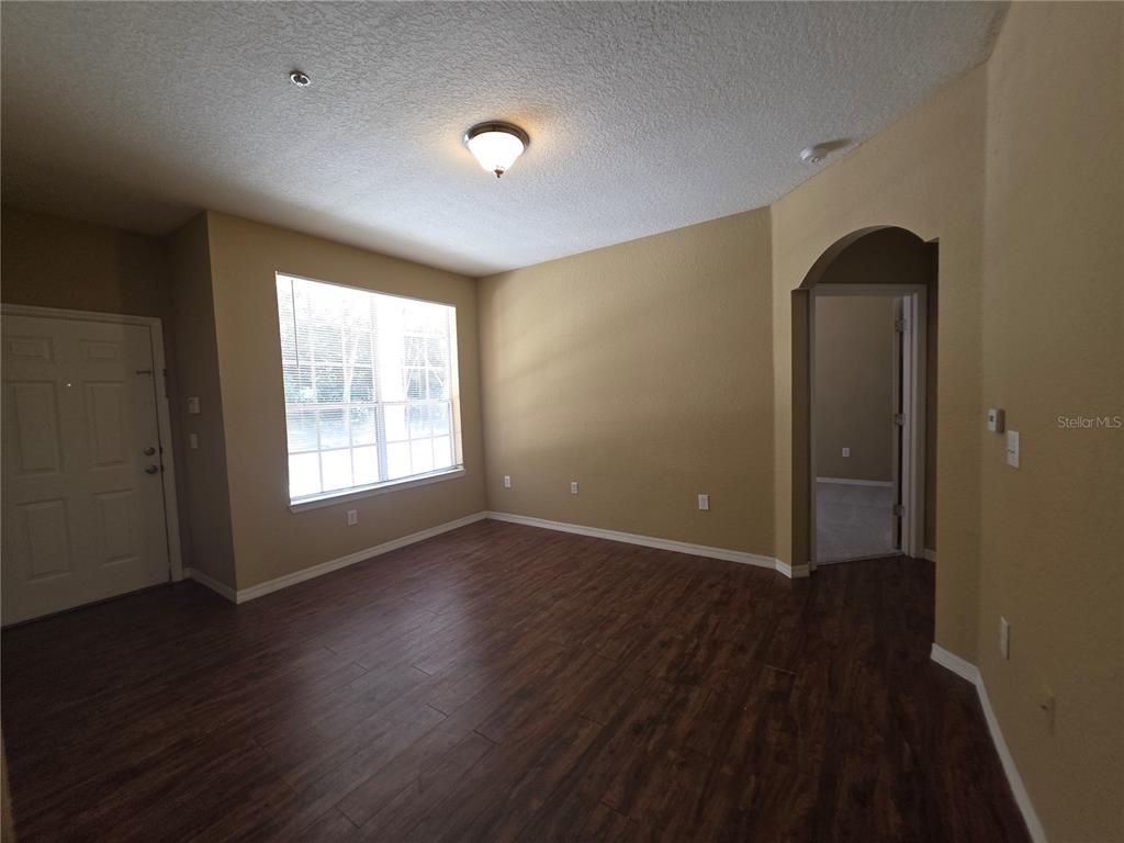 824 Grand Regency Pointe, Unit 101 Altamonte Springs, FL 32714 - Photo 5 of 14 an empty room with wooden floor and windows