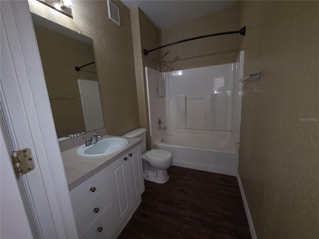 824 Grand Regency Pointe, Unit 101 Altamonte Springs, FL 32714 - Photo 9 of 14 a bathroom with a granite countertop sink toilet a shower and a mirror