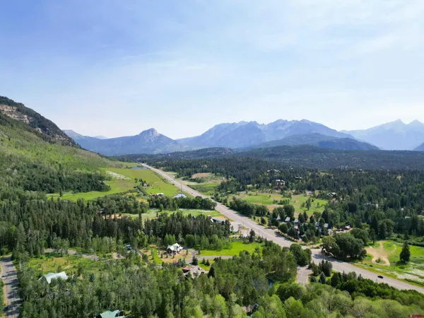 a view of a lush green hillside and houses