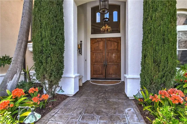 front view of house with a yard and palm trees