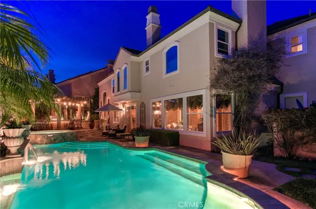 a view of a house with a small yard plants and a fountain
