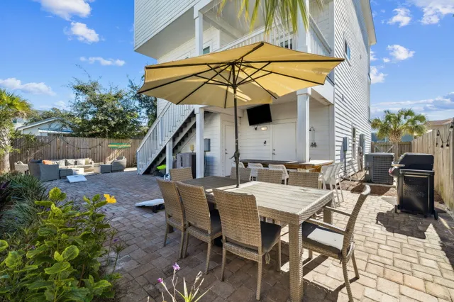 a view of a patio with a table and chairs under an umbrella