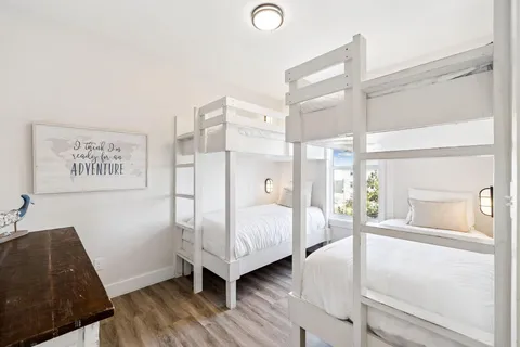 a bedroom with a bed wooden floor and window