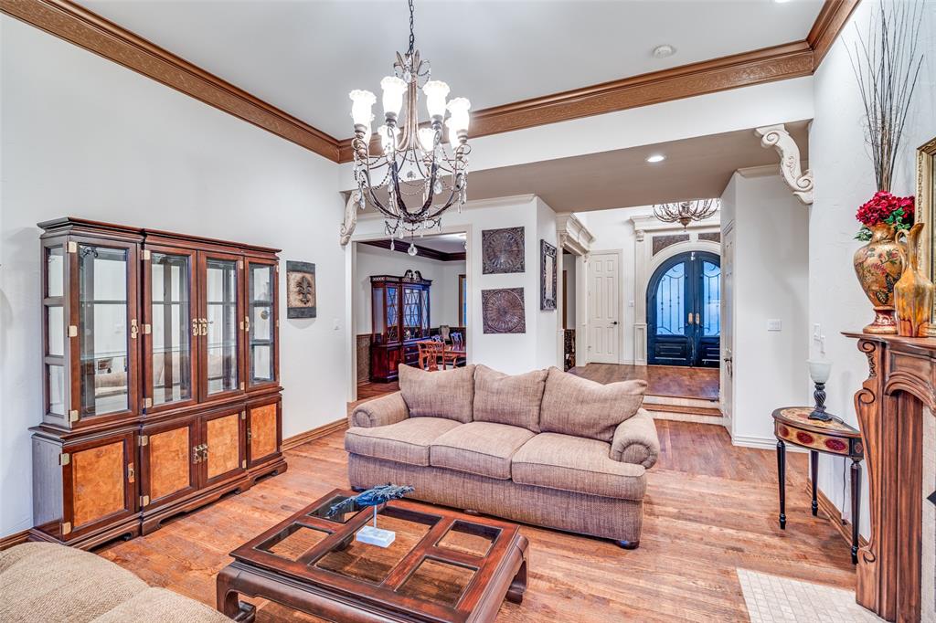390 Oak Ridge Drive Fairview, TX 75069 - Photo 6 of 12 a living room with furniture a chandelier and wooden floor