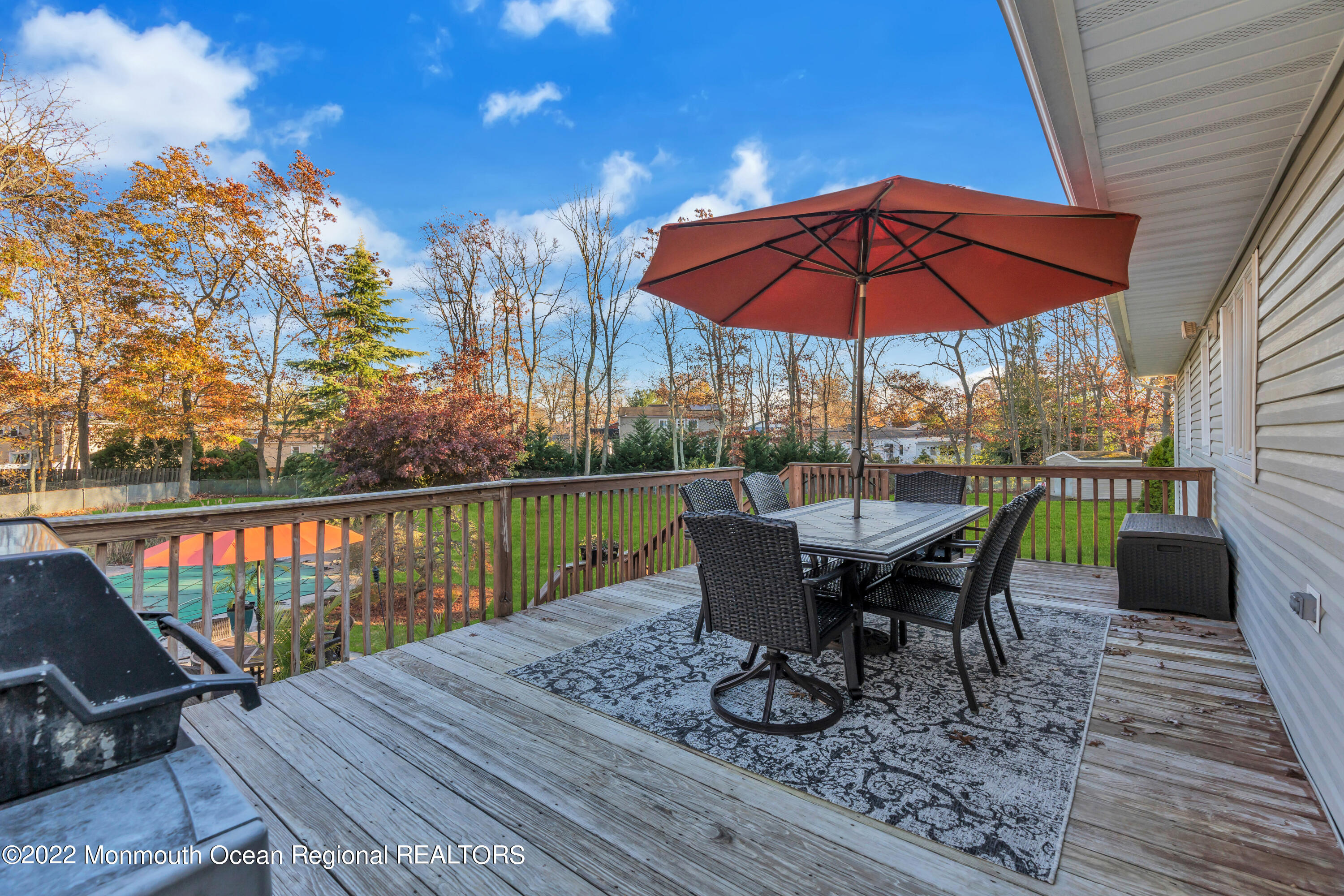 115 Greymoor Road Howell, NJ 07731 - Photo 11 of 38 a view of a roof deck with table and chairs under an umbrella with wooden floor
